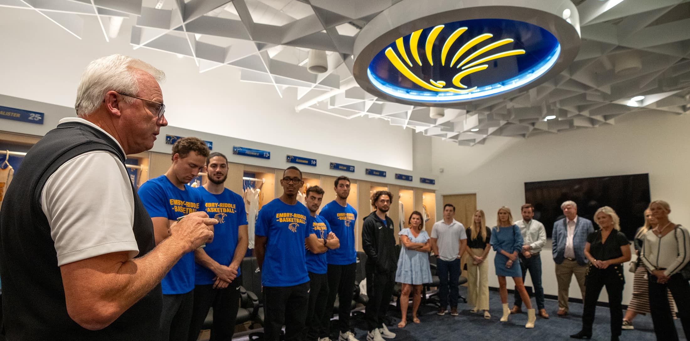 Coach Ridder, team and supporters in Adams locker room. 