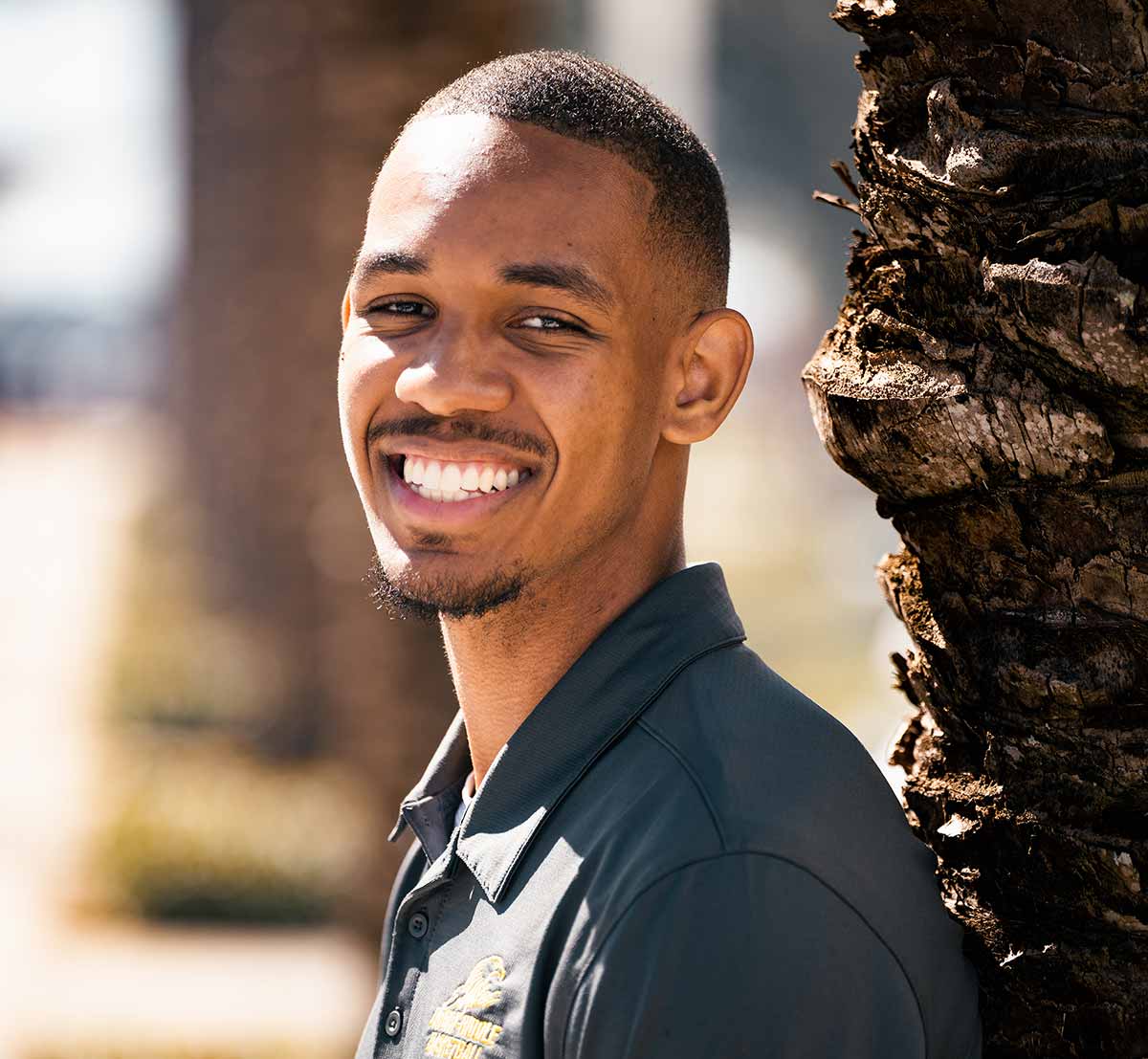 Calvin Freeman stands next to palm tree