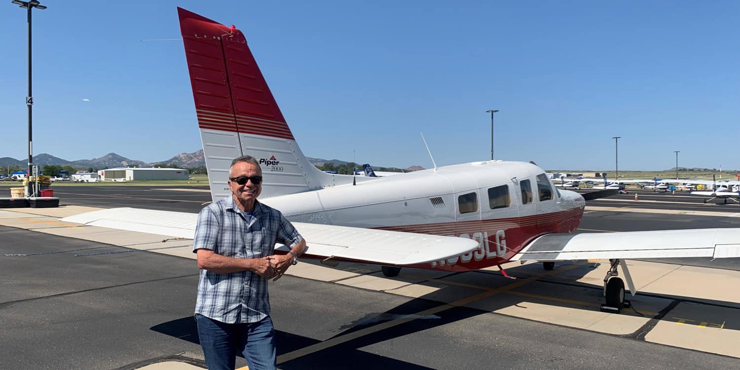 Ken Jillson standing in front of his aircraft