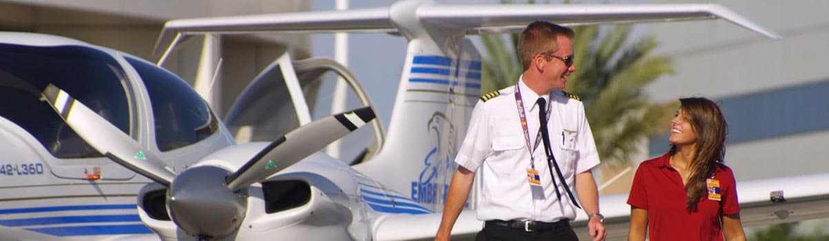 two flight students walking by an airplane