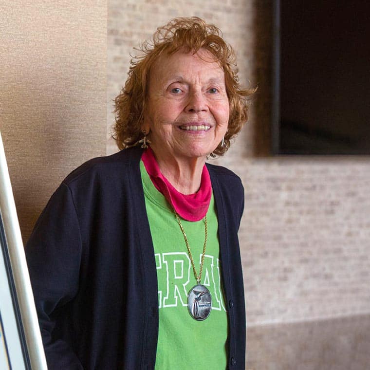 Woman in her eighties – Helen Wessel - wears an Embry-Riddle t-shirt and blazer, posing for the camera.