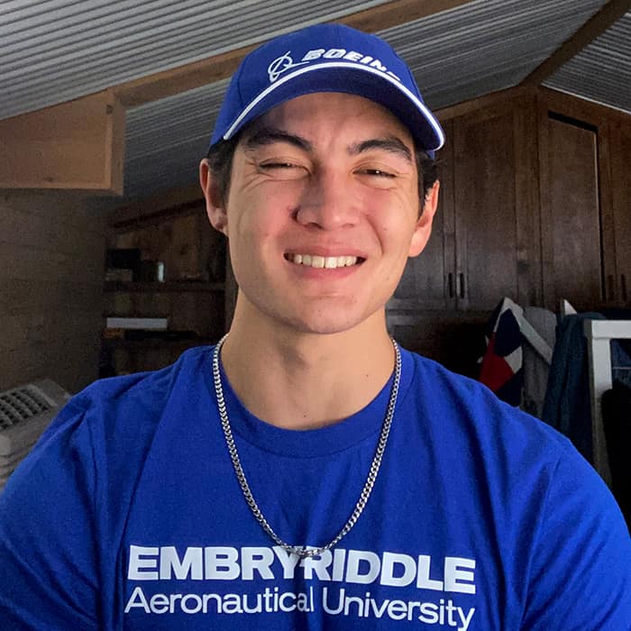 Male student wears a gold chain with his Boeing cap and Embry-Riddle t-shirt.