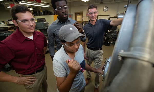 FedEx Purple Runway scholarship recipients working on a jet engine
