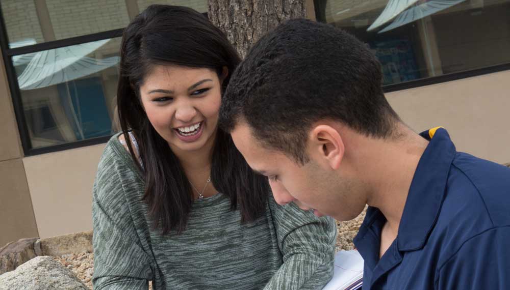 two students laughing and working