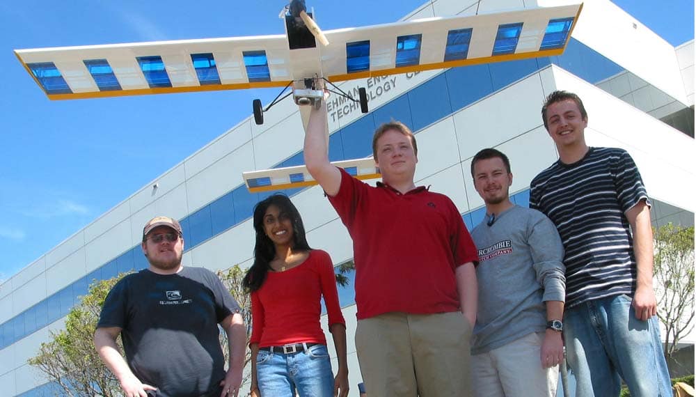Embry-Riddle students hold a remote-control airplane.