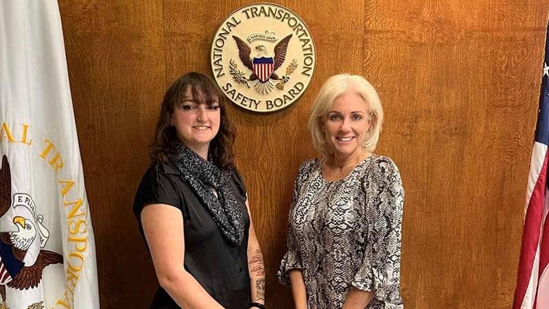 Embry-Riddle intern with NTSB representative standing in front of NTSB sign