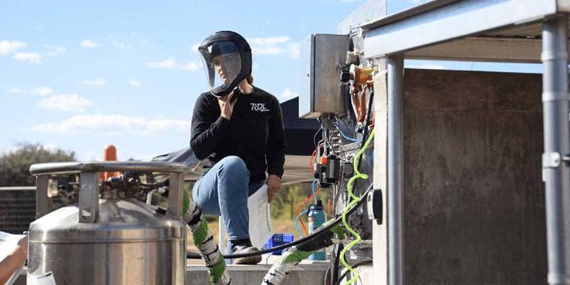 Olivia Wood stands near Rocket launch equipment
