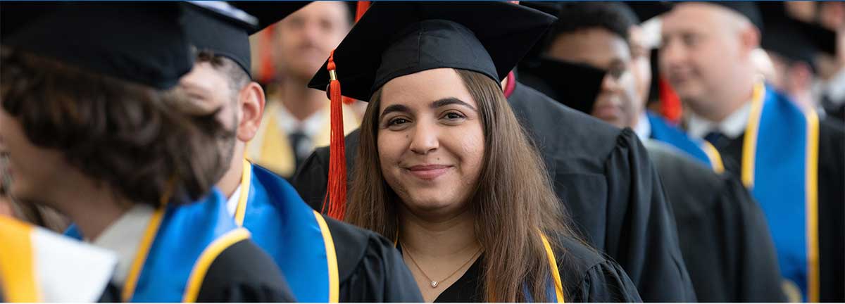 Female Graduate stands in line with other grads