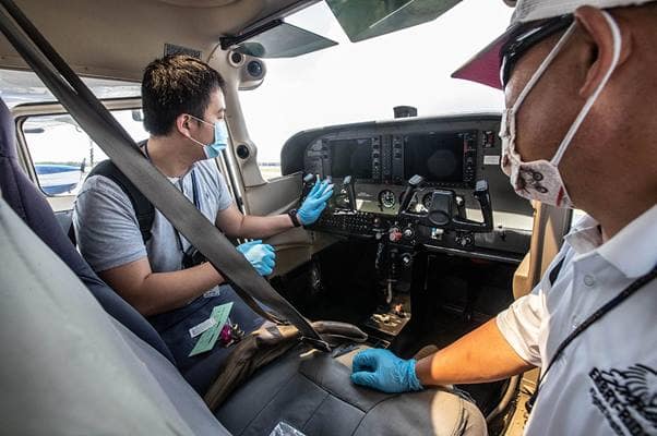 A student pilot cleans the cockpit before a flight.