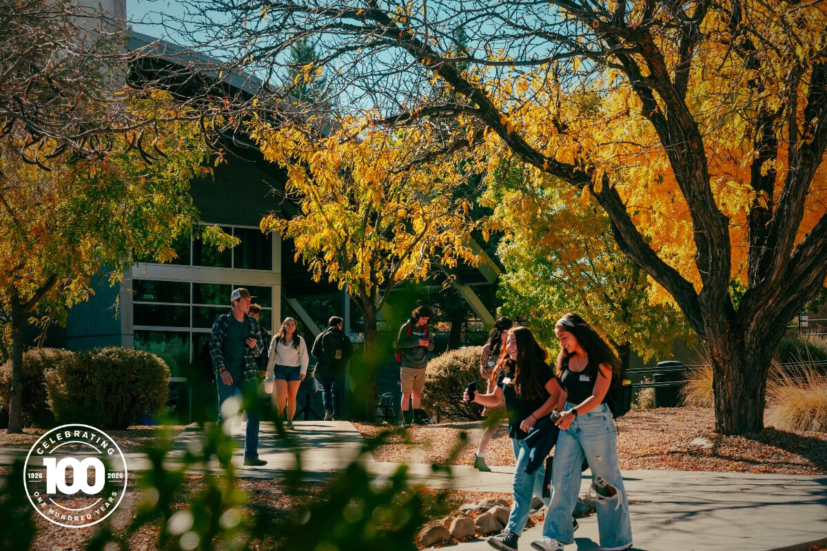 Students walk along a shaded path outside Embry-Riddle’s Aerospace Experimentation and Fabrication Building on the Prescott Campus, surrounded by bright yellow fall foliage and afternoon sunlight.