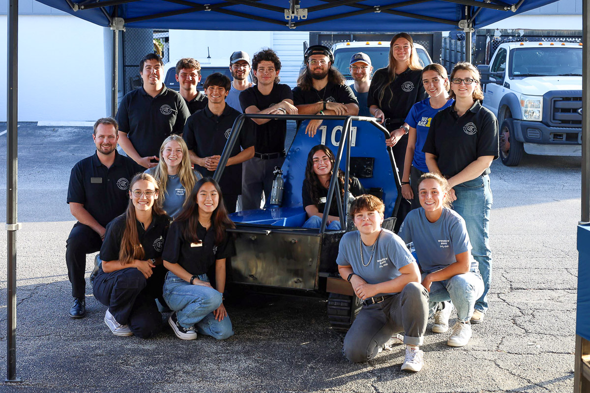 Embry-Riddle's Baja SAE team stands in front of its tracked vehicle
