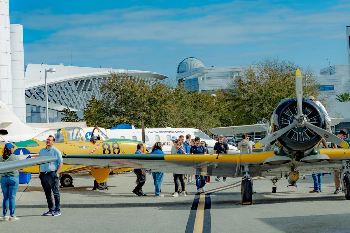 Students, faculty, staff and other aviation enthusiasts tour a lineup of historical planes displayed during an Aviation Week event on Embry-Riddle’s Daytona Beach Campus. 